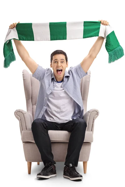 Sports fan zitten in een leunstoel en een sjaal te houden — Stockfoto