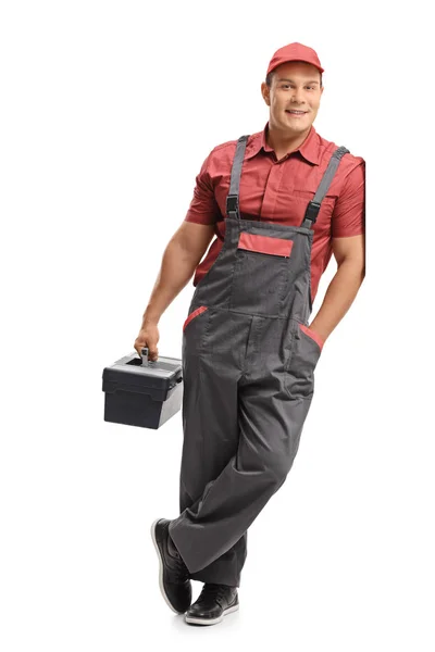 Repairman holding a toolbox and leaning against a wall — Stock Photo, Image