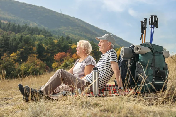 Escursionisti anziani seduti su una coperta — Foto Stock