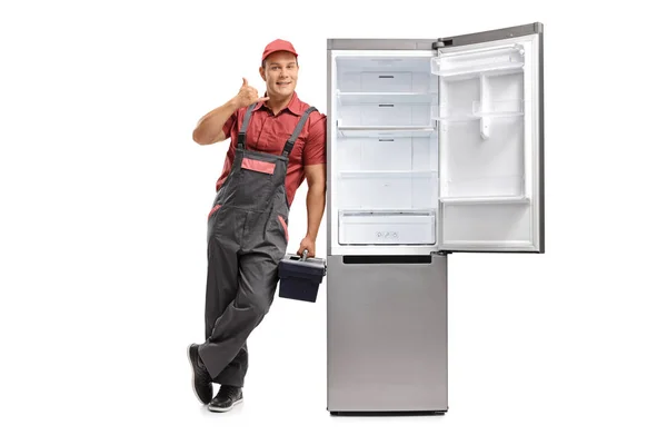 Serviceman leaning against an fridge and making a call me — Stock Photo, Image