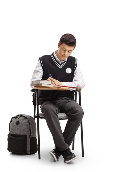 Estudante sentado em uma cadeira de escola e tomar notas — Fotografia de Stock