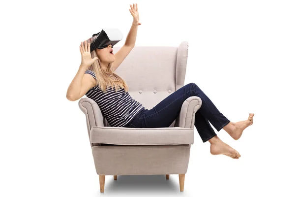 Mujer sentada en un sillón experimentando la realidad virtual — Foto de Stock