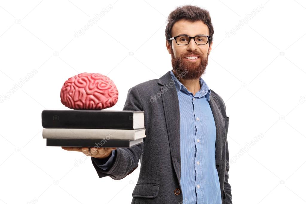 Professor showing a stack of books and a brain model