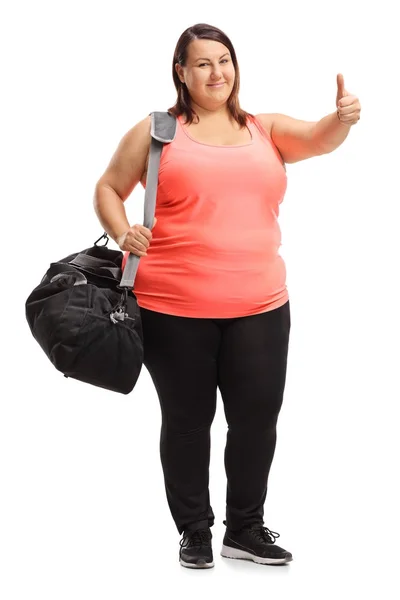 Donna con una borsa sportiva facendo un gesto pollice in su — Foto Stock