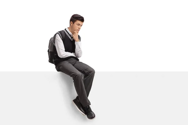 Pensive adolescent étudiant assis sur un panneau — Photo
