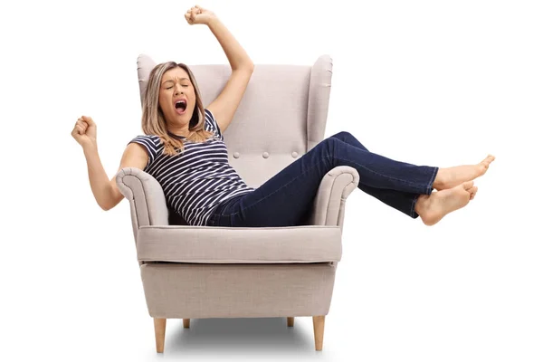 Tired woman lying in an armchair and yawning — Stock Photo, Image