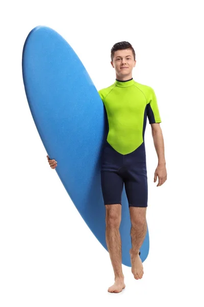 Surfista adolescente sosteniendo una tabla de surf y caminando — Foto de Stock