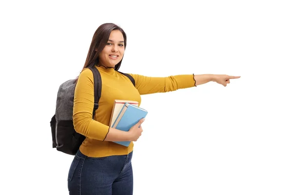 Étudiant adolescent avec un sac à dos et des livres pointant — Photo