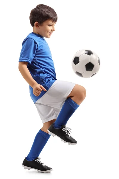 Pequeño futbolista haciendo malabares con un balón — Foto de Stock