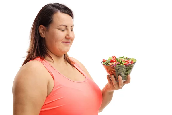 Толстая женщина смотрит на миску салата — стоковое фото