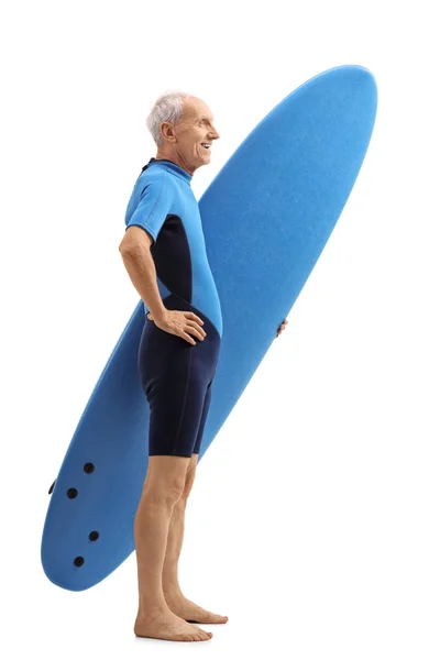 Senior in een wetsuit holding een surfplank en wachten in de rij — Stockfoto