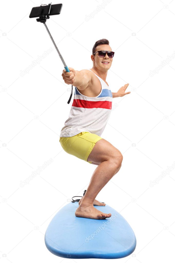 man surfing and taking a selfie with a stick