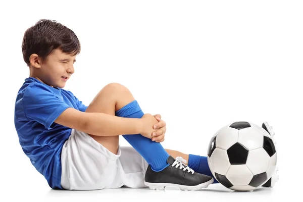 Injured little footballer holding his leg — Stock Photo, Image