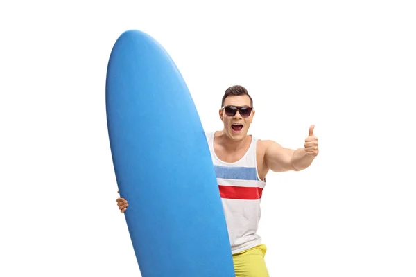 Surfista con una tabla de surf haciendo un pulgar hacia arriba signo — Foto de Stock