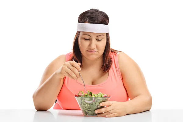 Mulher com sobrepeso triste olhando para uma tigela de salada — Fotografia de Stock