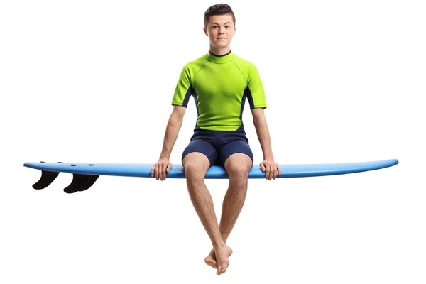 Teenager-Surfer sitzt auf einem Surfbrett — Stockfoto