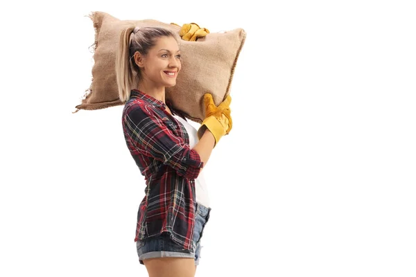 Female farmer holding a burlap sack on her shoulder — Stock Photo, Image