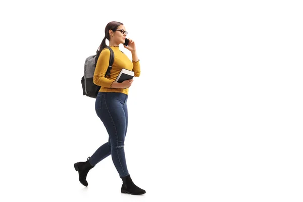 Estudante feminina andando e conversando em um telefone — Fotografia de Stock