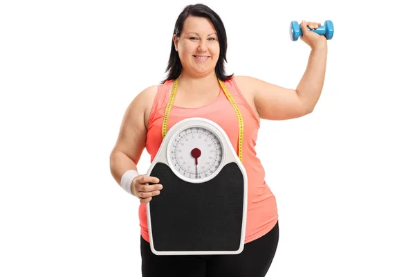 Vrouw met een schaal van gewicht en een halter overgewicht — Stockfoto