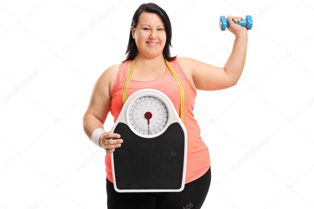 overweight woman with a weight scale and a dumbbell