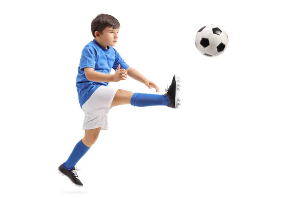 Soccer player kicking a football in mid-air — Stock Photo, Image