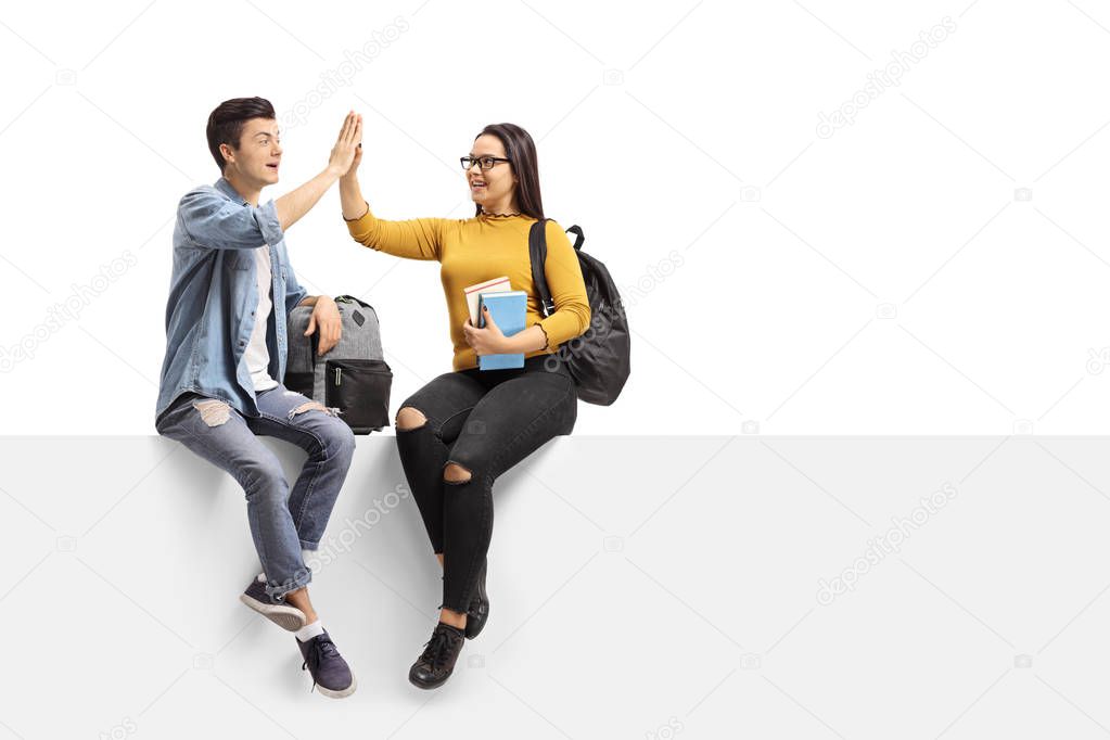 Teenage students high-fiving each other