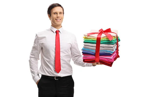 Мужчина со стопкой одежды с лентой в подарок — стоковое фото