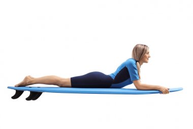 Genç kadın bir wetsuit üzerinde sörf tahtası yalan