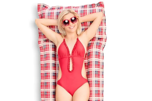 Woman in a swimming suit lying on an air mat — Stock Photo, Image