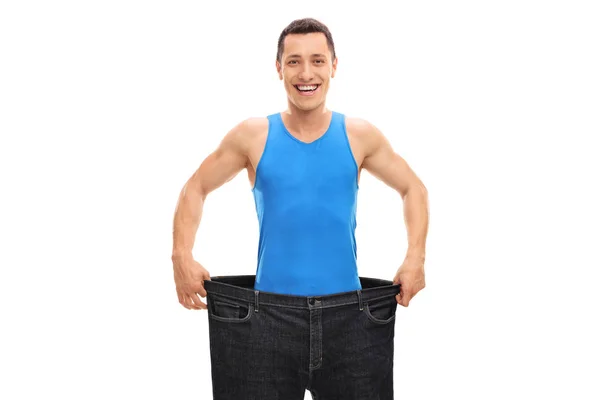 Happy guy in a pair of oversized jeans — Stock Photo, Image