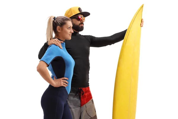 Male and a female surfers with a surfboard — Stock Photo, Image