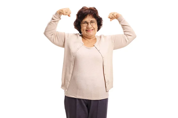Äldre kvinna flexar hennes biceps — Stockfoto