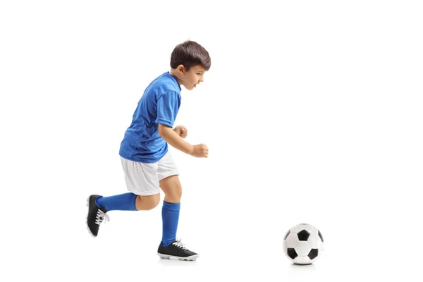 Pequeño futbolista corriendo hacia un fútbol — Foto de Stock