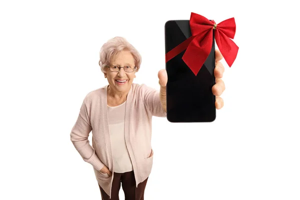 Donna che mostra un telefono avvolto con nastro come regalo — Foto Stock