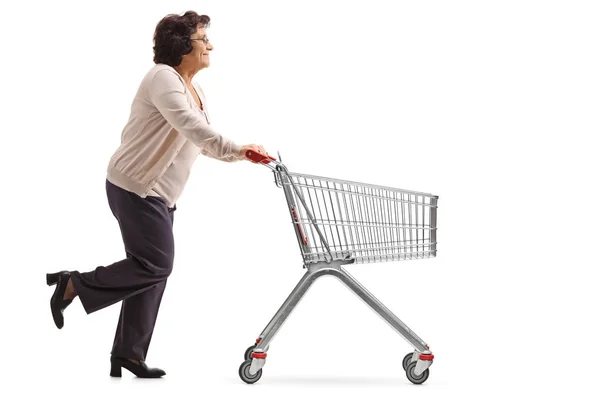 Woman running and pushing a shopping cart — Stock Photo, Image