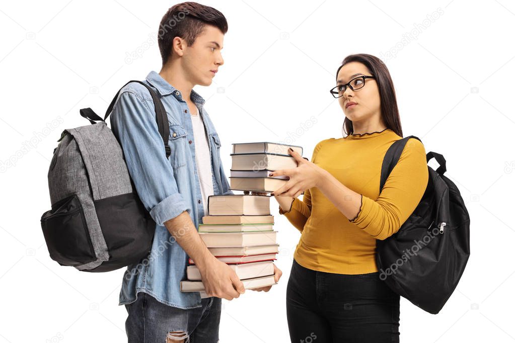 Female student giving a stack of books to a male student