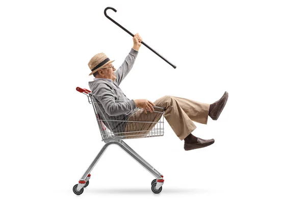 Mann mit Stock reitet in Einkaufswagen — Stockfoto