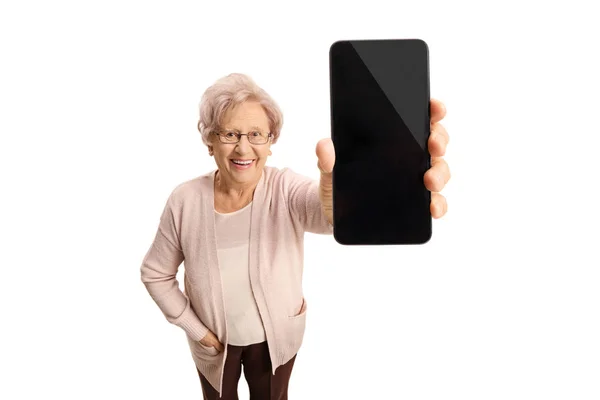 Senior dame toont een telefoon en glimlachen — Stockfoto