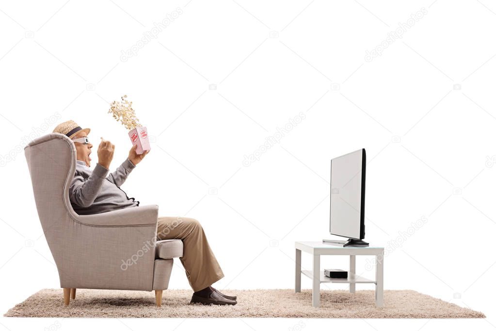 man with popcorn and 3D glasses watching television