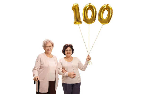 Mulheres maduras com um número cem balões — Fotografia de Stock