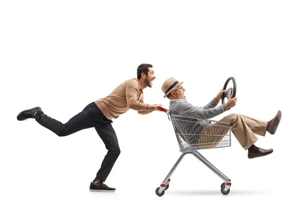 Man pushing a shopping cart with a mature man — Stock Photo, Image