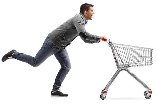 Chico corriendo y empujando un carrito de compras — Foto de Stock