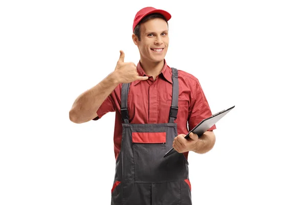 Serviceman with a clipboard making a call me gesture — Stock Photo, Image