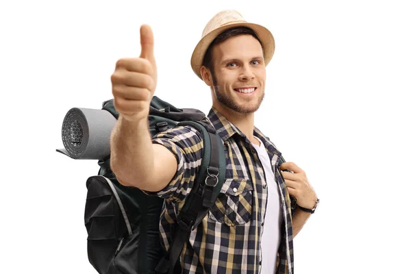 Turista con una mochila haciendo un cartel de pulgar hacia arriba —  Fotos de Stock