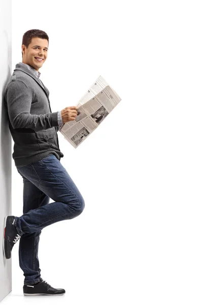 Um tipo com um jornal encostado a uma parede — Fotografia de Stock
