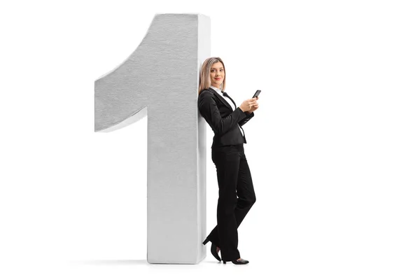 Woman with a phone against a cardboard number one — Stock Photo, Image