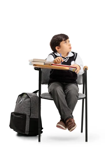 Испуганный школьник, сидящий в школьном кресле — стоковое фото