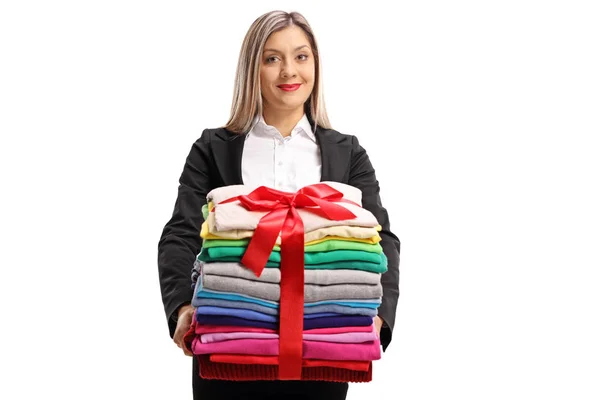 Mulher segurando uma roupa com fita como um presente — Fotografia de Stock