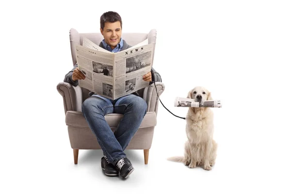 Un homme lisant un journal et un labrador récupérant avec un journal — Photo