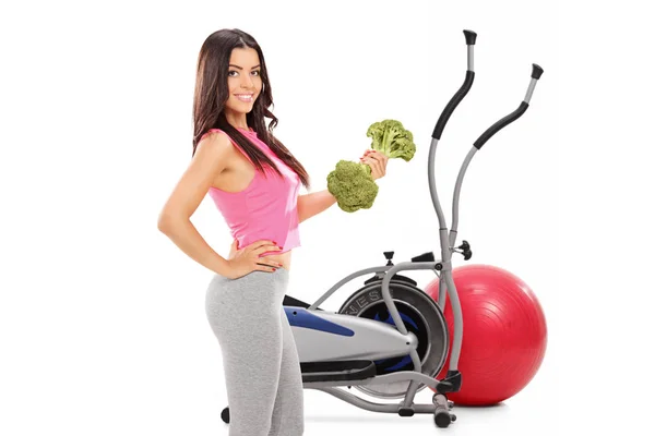 Woman with a broccoli dumbbell — Stock Photo, Image